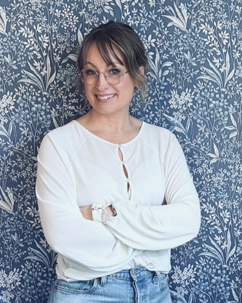 Person står med armarna i kors och ler mot kameran.