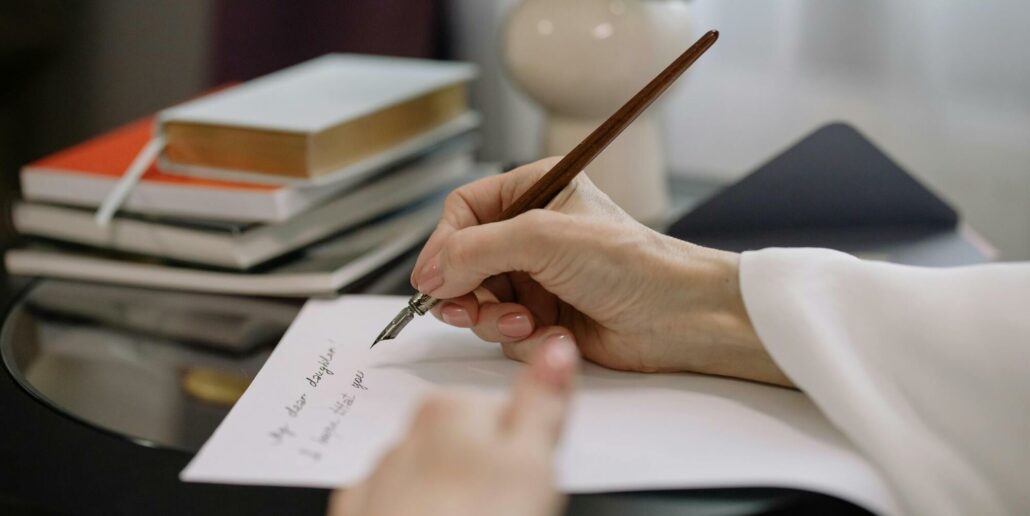 Kvinna som sitter och skriver reflekterande i sin skrivbok