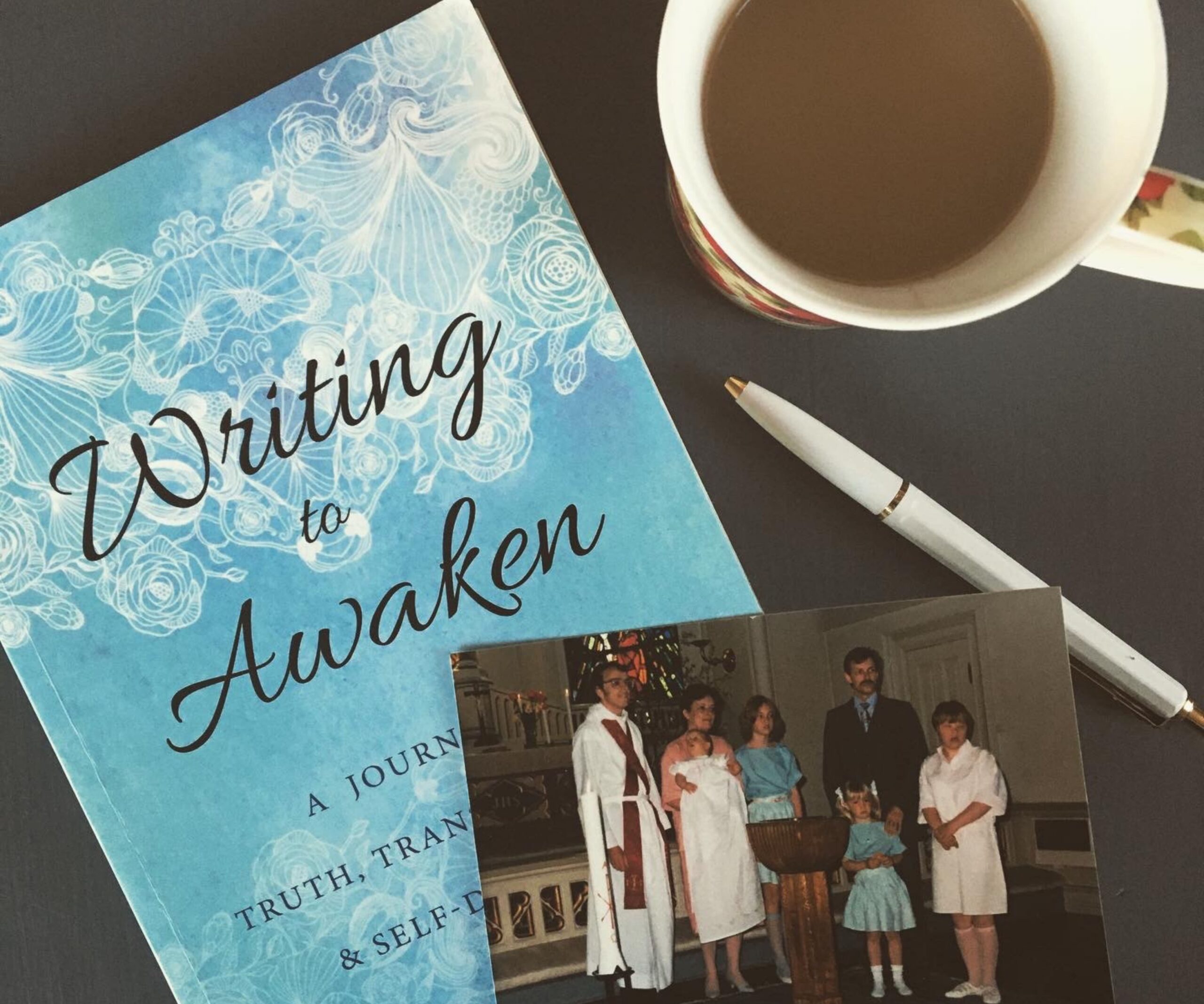 Arbetsyta med kaffe, bok och penna för skrivprocess.