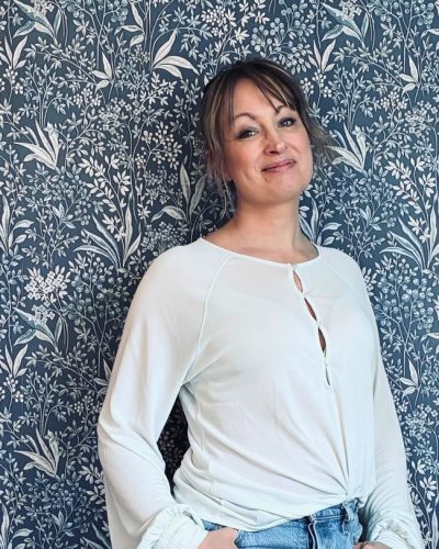 Person som lutar sig mot en vägg och tittar in i kameran.