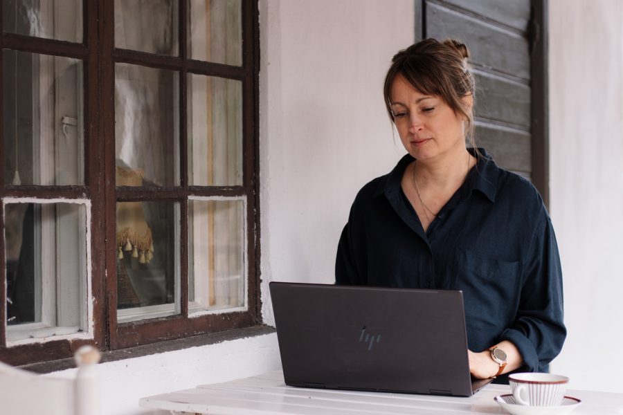 Person sitter vid dator och skriver.