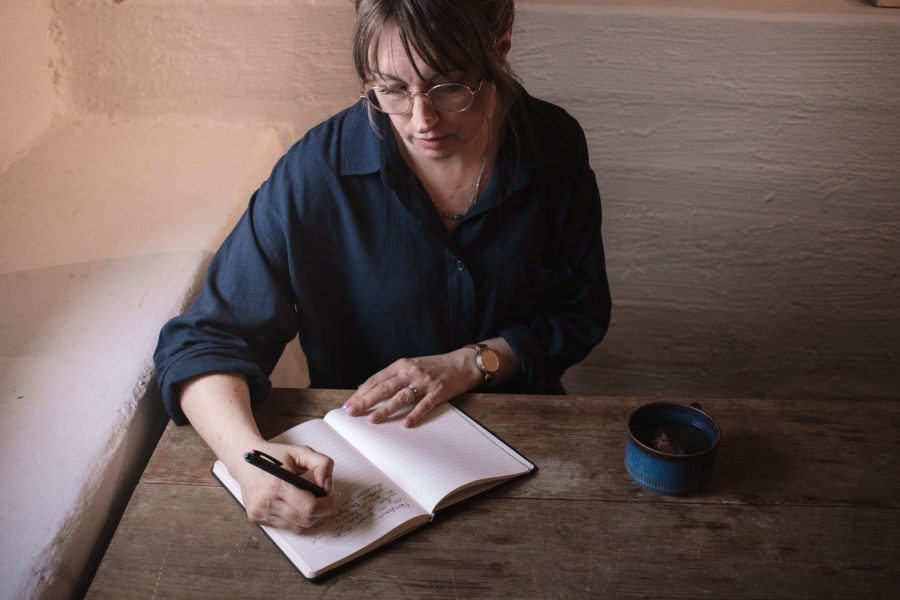 Person skriver i skrivbok.